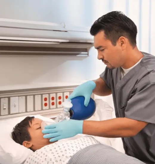 Clinician using a Vyaire self-inflating resuscitation device on a pediatric patient.